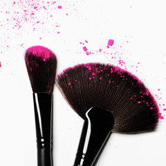 Makeup brush on white background with colorful pigment powder