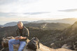 © Sam Diephuis/Blend Images - Older Caucasian man using cell phone on rocky hilltop