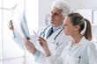 © stokkete - Radiologist checking an x-ray with his assistant