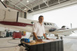 © Mark Edward Atkinson/Tracey Lee/Blend Images - Hispanic man working in airplane hangar