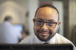 © Disability Images/Blend Images - Mixed race businessman with down syndrome working on computer