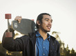 © Erik Isakson/Blend Images - Chinese man carrying skateboard outdoors