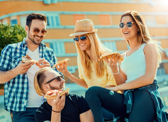 Group of friends taking their slices of pizza