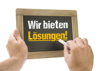 Canvas Print - Hand schreibt Wir bieten Lösungen! auf Kreidetafel