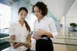 © Peathegee Inc/Blend Images - Businesswomen using tablet computer in lobby