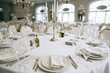 Elegant wedding reception white table arrangement restaurant, 
candlestick on table. Plates, forks and glasses