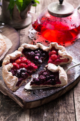 Wall Mural - Blueberry,cherry,raspberry and blackcurrant galette on w wooden background.