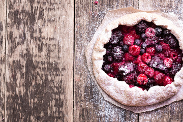 Blueberry,cherry,raspberry and blackcurrant galette on w wooden background.