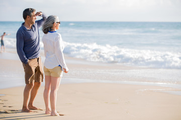 mid aged couple laying out on the beach