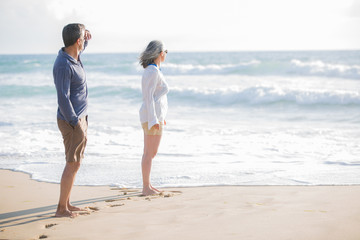 Wall Mural - mid aged couple laying out on the beach