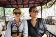 © Roberto Westbrook/Blend Images - Businesswomen riding in tuk tuk taxi