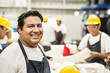 © Sollina Images/Blend Images - Worker smiling in manufacturing plant