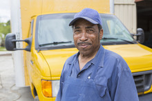African American Worker Smiling By Truck