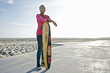 © Peathegee Inc/Blend Images - Older Black woman holding skateboard on beach