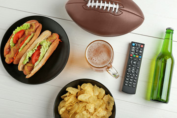 Wall Mural - TV remote control with ball, snack and beer on white background