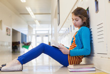 Girl Reading Book In The School Corridor