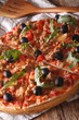 © FomaA - Hot pizza with tuna, olives and arugula close-up. vertical