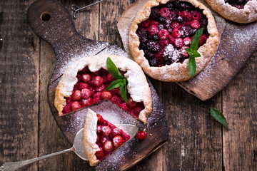 Blueberry,cherry,raspberry and blackcurrant galette on w wooden background.