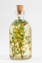 Wall Mural - Bottle of thyme essential oil or infusion and basket with healin