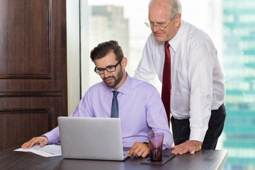 Wall Mural - Senior Businessman Helping Young Colleague