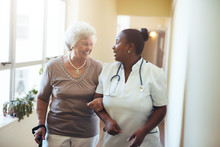 Nurse Assisting Senior Woman At Nursing Home