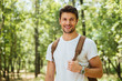© Drobot Dean - Closeup of cheerful young man standing and smiling in forest