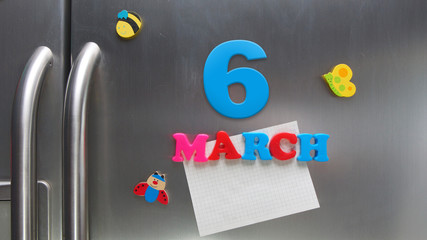 March 6 calendar date made with plastic magnetic letters holding a note of graph paper on door refrigerator