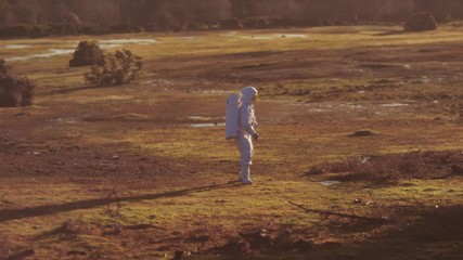 astronaut walking in woodland area looking for signs of life