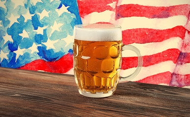 Wall Mural - Glass of beer on wooden table. USA flag background.