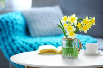 Wall Mural - Yellow narcissus on white table in room interior