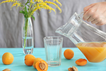 Canvas Print - Woman pouring apricot juice in glass