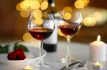 Poster - Romantic composition with wine and candle on blurred background