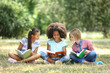 © Africa Studio - Cute kids reading books on green grass