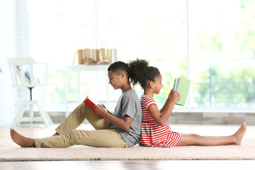 Wall Mural - Cute boy and girl reading books at home