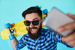 © kegfire - Young hipster with beard in glasses taking selfie and smiling isolated on the blank white background