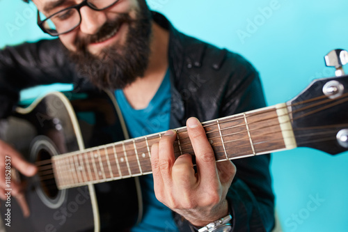 Fotografija Bearded hipster man hand playing on acoustic guitar.