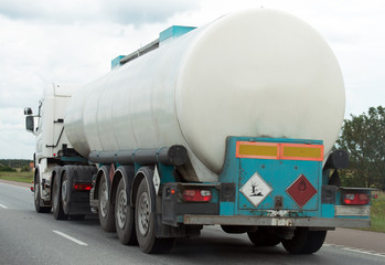 White gas tanker truck on highway.