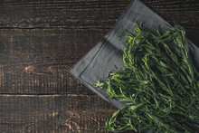 Tarragon On The Grey Napkin On The Wooden Table Top View