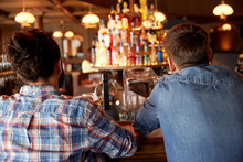 Close Up Of Male Friends At Bar Counter In Pub