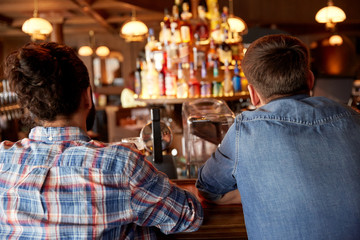 Sticker - close up of male friends at bar counter in pub