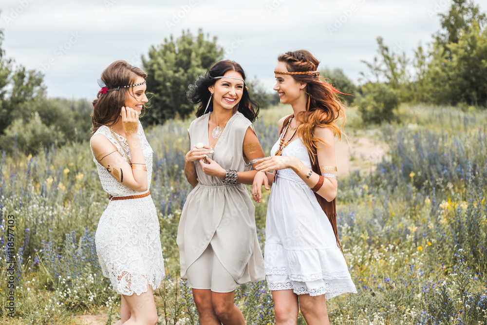Three beautiful cheerful hippie girls, best friends, the outdoors, cute  smile, trendy hairstyles, feathers in her hair, white dress, tattoo flash, gold  accessories, Bohemian, boho style, fashion indie Stock Photo | Adobe
