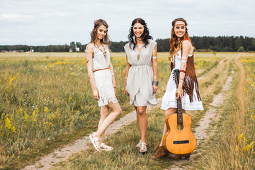 Wall Mural - Three beautiful cheerful hippie girls, best friends, the outdoors, cute smile, trendy hairstyles, feathers in her hair, white dress, tattoo flash, gold accessories, Bohemian, boho style, fashion indie