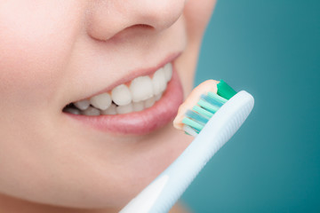 Wall Mural - woman holds toothbrush with toothpaste cleaning teeth