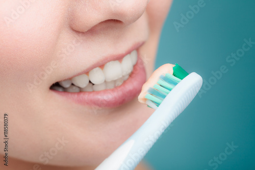 Fotografie, Obraz woman holds toothbrush with toothpaste cleaning teeth