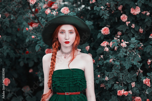Photographie Fille aux cheveux roux avec des yeux bleus et une peau pâle dans un chapeau vert et habille-toi avec une ceinture rouge