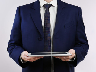 Poster - Businessman with tablet on light background