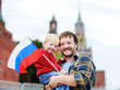 © Maria Sbytova - Family with russian flag with Moscow Kremlin on background
