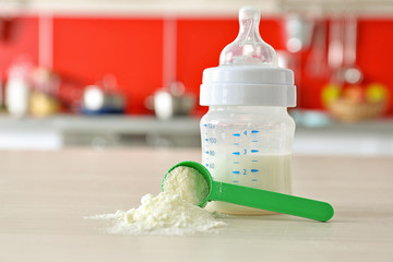 Feeding bottle and baby milk formula on kitchen background