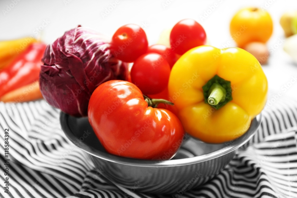 Bowl with fresh vegetables on napkin