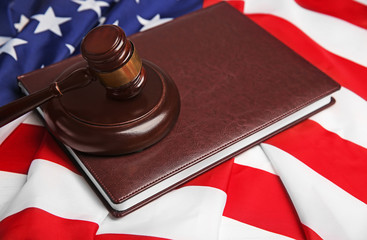 Wall Mural - Judge gavel and book on American flag, closeup